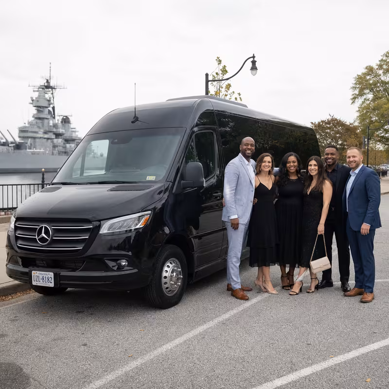 Group beside a Mercedes Sprinter limo from the Norfolk fleet at the beach