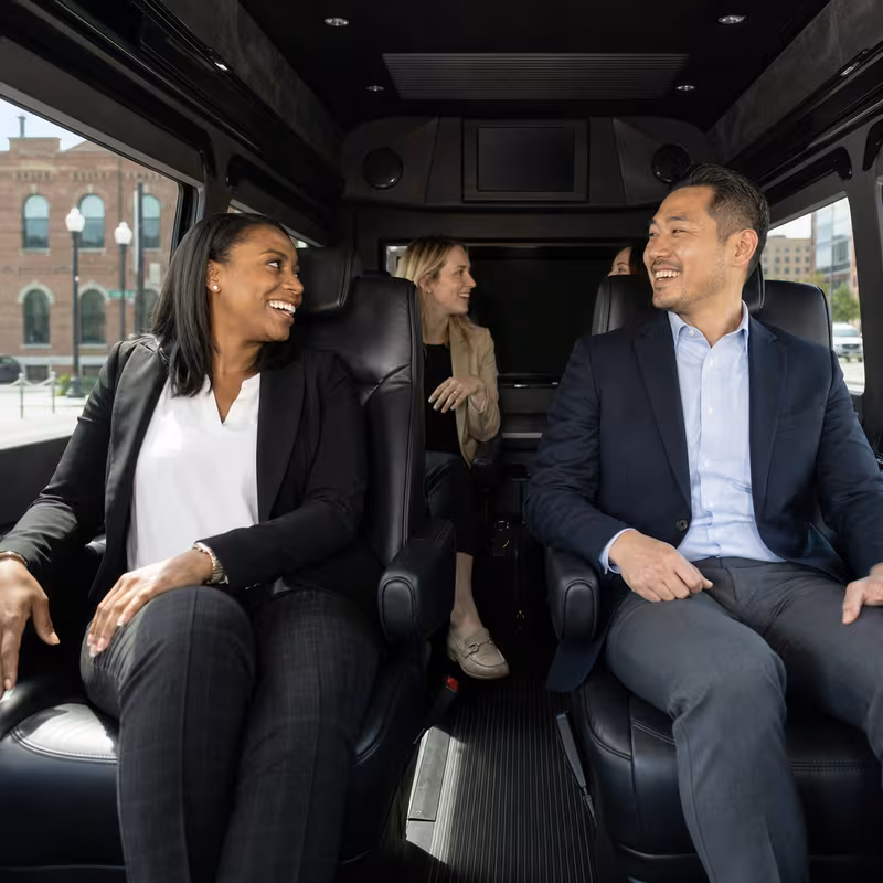 Group boarding a white charter bus for Corporate Transportation transportation in Norfolk