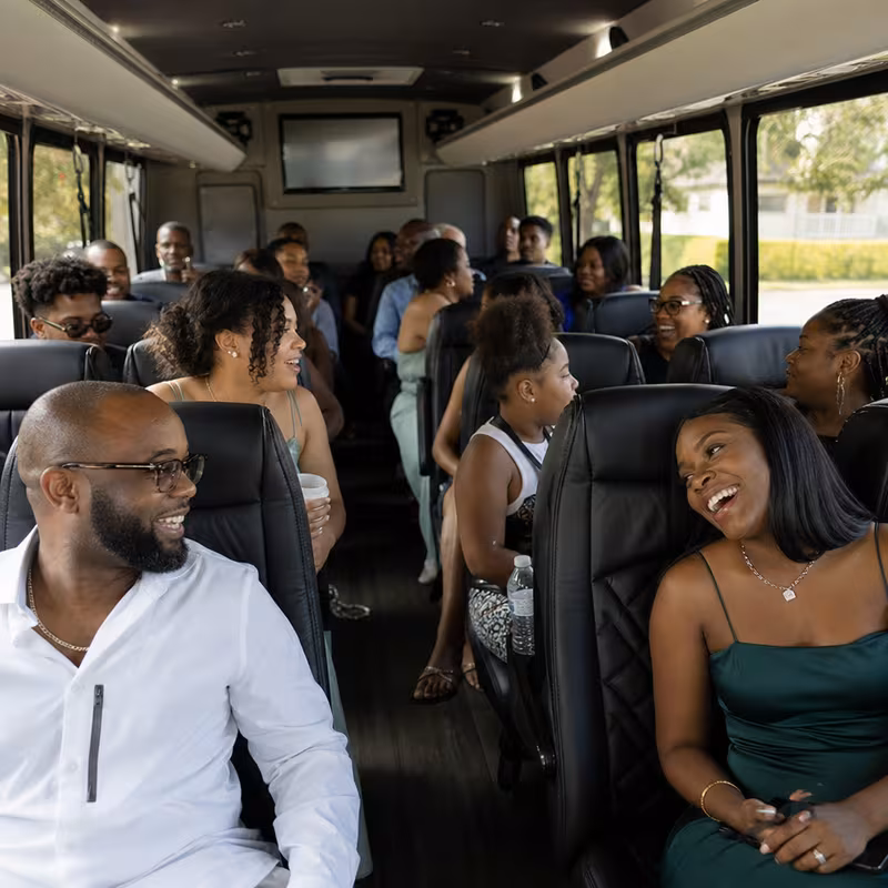 Group boarding a white charter bus for Private Event Transportation transportation in Norfolk