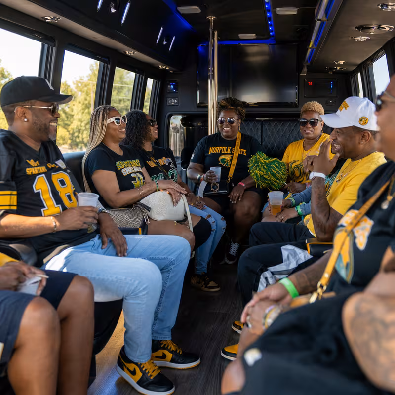 Group boarding a white charter bus for Sporting Event Transportation transportation in Norfolk