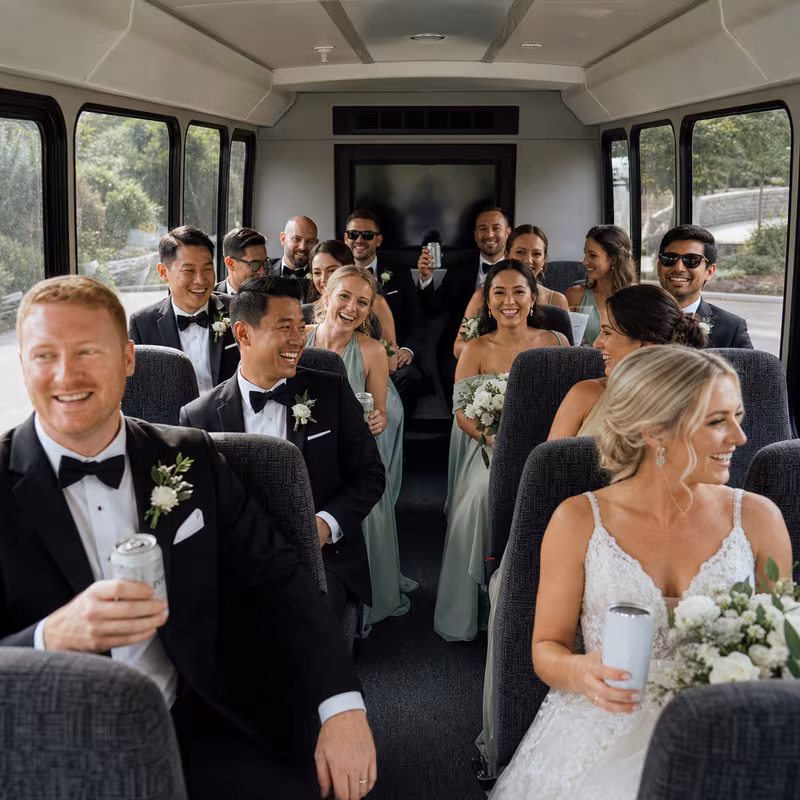 Group boarding a white charter bus for Wedding Transportation transportation in Norfolk